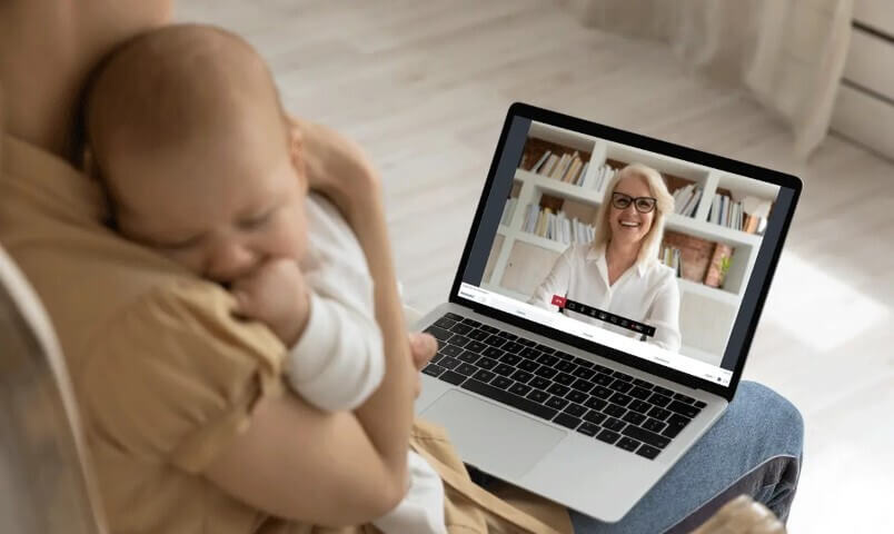Moeder met net geboren baby aan het videobellen op een Ipad met de kraamverzorgster